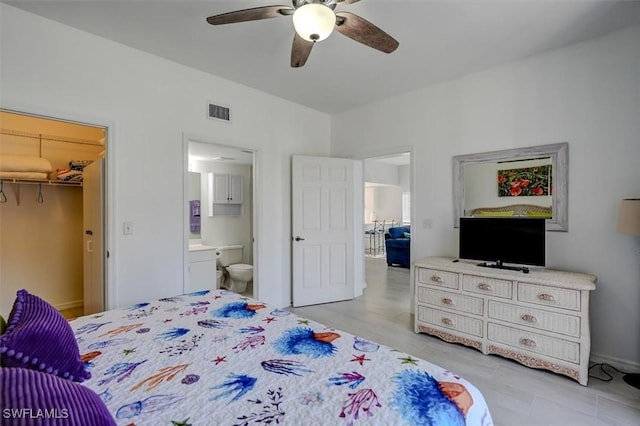 bedroom with a spacious closet, a closet, ceiling fan, and ensuite bathroom