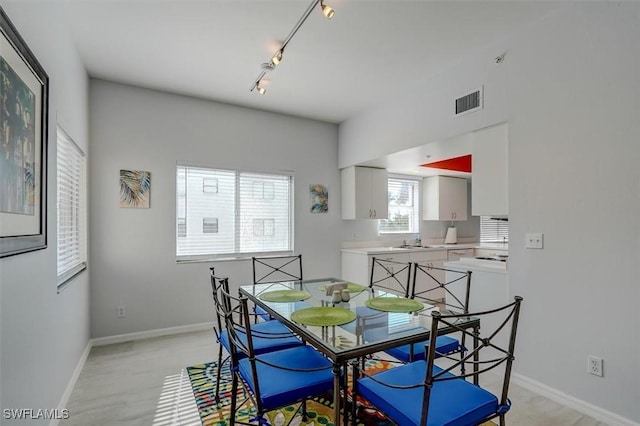 dining space with sink and track lighting