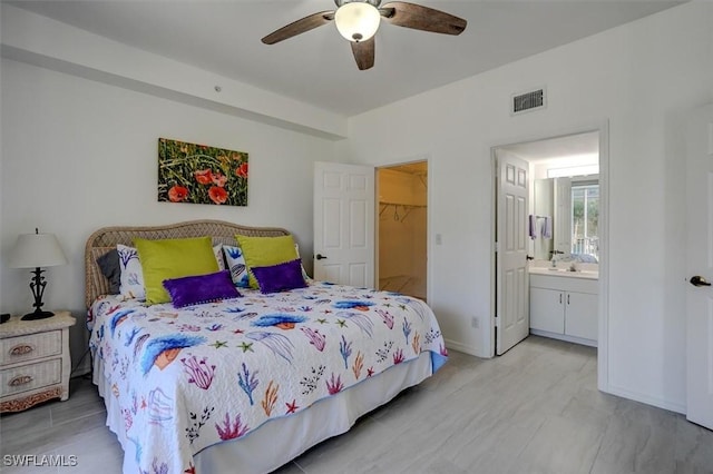 bedroom with connected bathroom, a spacious closet, a closet, and ceiling fan