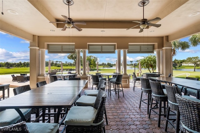 view of patio featuring ceiling fan and exterior bar