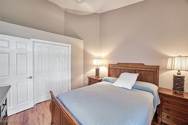 bedroom featuring ceiling fan, light wood-type flooring, and a closet