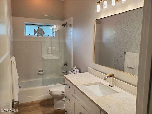 full bathroom featuring vanity, wood-type flooring, tiled shower / bath combo, and toilet