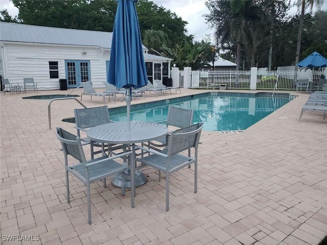 view of swimming pool featuring a patio area and french doors