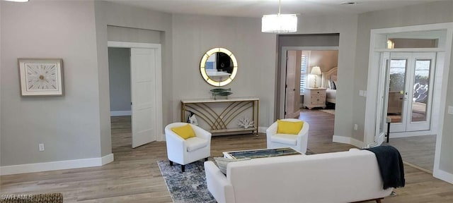 living room with french doors and light wood-type flooring