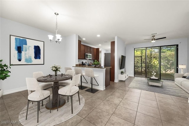 dining area featuring ceiling fan with notable chandelier and light tile patterned flooring