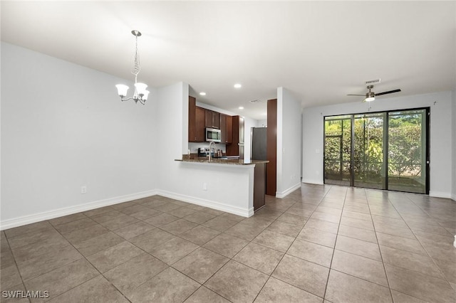 kitchen featuring kitchen peninsula, ceiling fan with notable chandelier, decorative light fixtures, and light tile patterned flooring