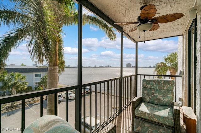 balcony featuring a water view and ceiling fan