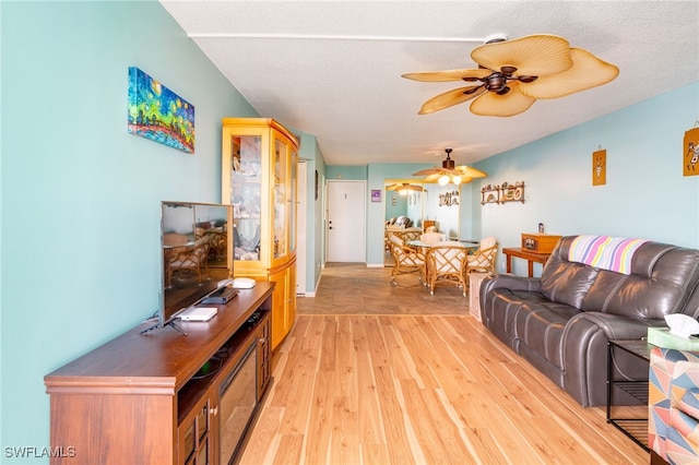 living area featuring light wood-type flooring and a ceiling fan