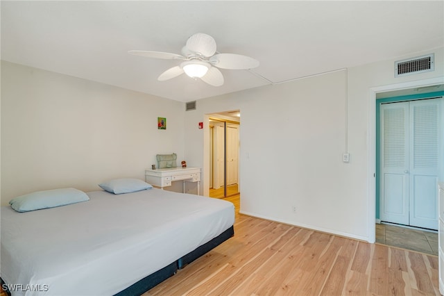 bedroom with light wood-type flooring, baseboards, visible vents, and a ceiling fan