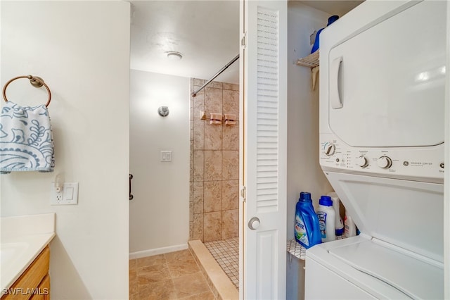 laundry area featuring stacked washer and dryer, laundry area, and light tile patterned floors