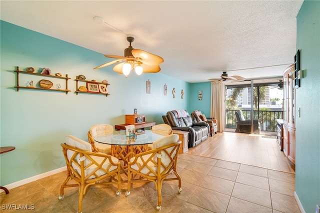 dining area featuring a textured ceiling, light tile patterned flooring, a ceiling fan, and baseboards