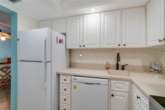 kitchen with light countertops, white appliances, a sink, and white cabinets