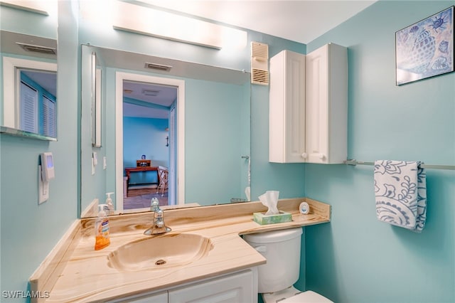 ensuite bathroom with toilet, visible vents, connected bathroom, and vanity