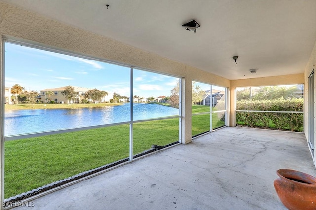 unfurnished sunroom featuring a water view