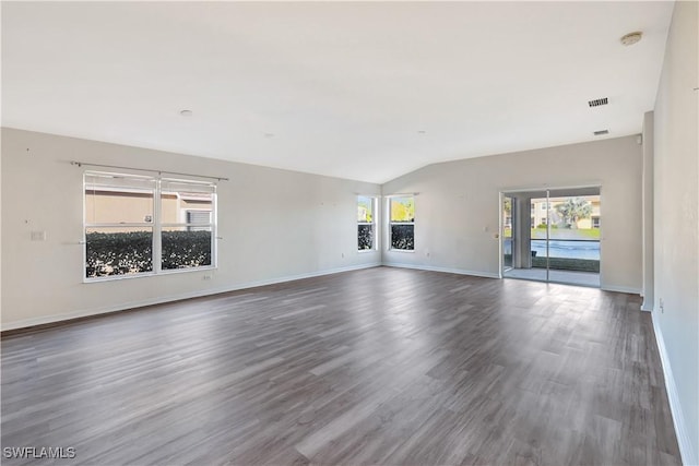 unfurnished living room with dark wood-type flooring and vaulted ceiling