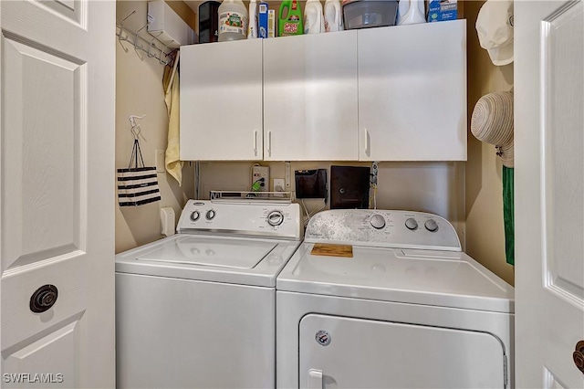 laundry room featuring cabinets and washing machine and clothes dryer