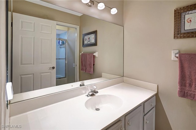 bathroom with vanity and a shower with shower door