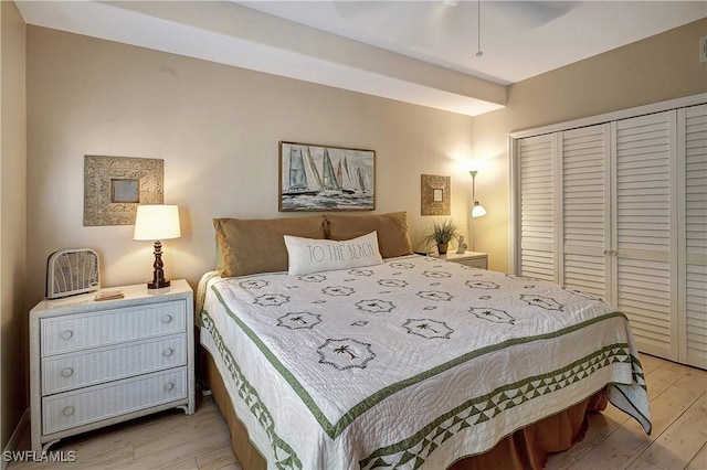 bedroom featuring ceiling fan, a closet, and light hardwood / wood-style floors