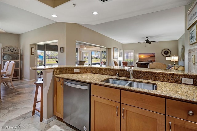 kitchen featuring light stone counters, sink, ceiling fan, and stainless steel dishwasher