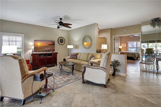 tiled living room featuring ceiling fan and a healthy amount of sunlight