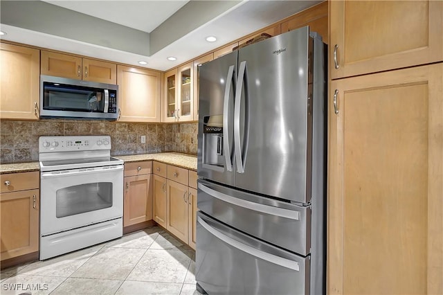 kitchen featuring tasteful backsplash, light tile patterned flooring, and stainless steel appliances