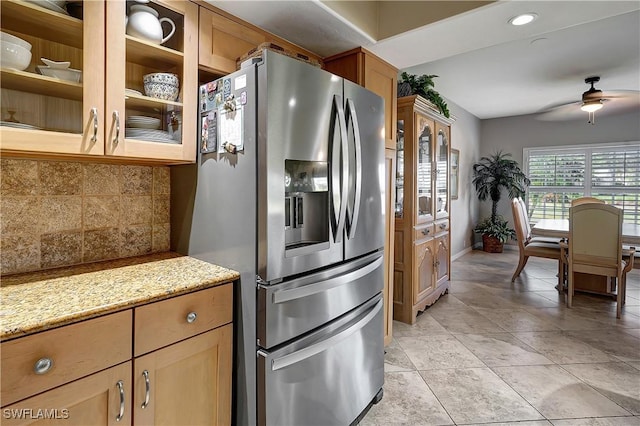 kitchen with stainless steel fridge, ceiling fan, light stone countertops, and light tile patterned floors