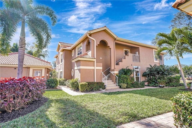 mediterranean / spanish-style home with a front lawn