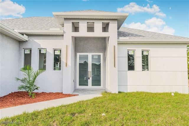 view of exterior entry with french doors and a yard