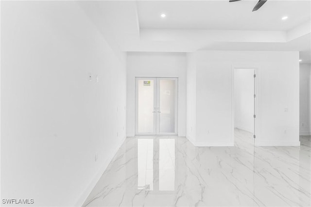 spare room with ceiling fan, a tray ceiling, and french doors