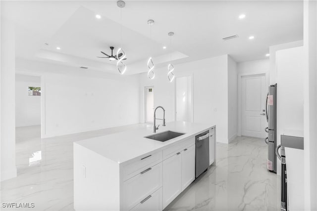 kitchen featuring white cabinets, a raised ceiling, hanging light fixtures, sink, and appliances with stainless steel finishes