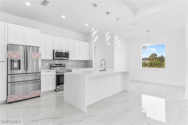 kitchen with a center island with sink, decorative light fixtures, white cabinetry, and stainless steel appliances