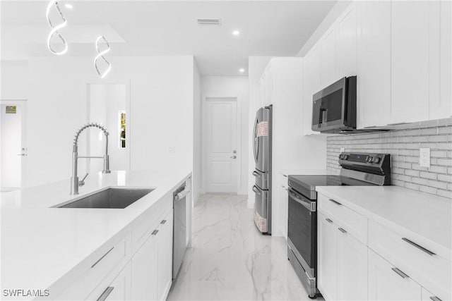 kitchen with decorative backsplash, white cabinetry, sink, and stainless steel appliances