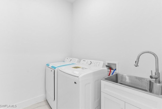 laundry room featuring cabinets, washing machine and dryer, and sink