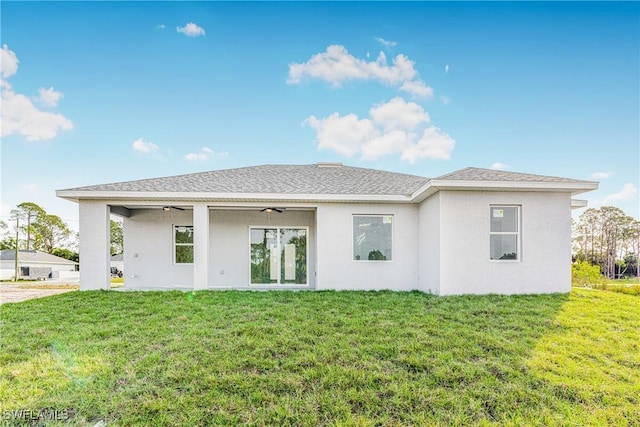 back of property featuring a lawn and ceiling fan