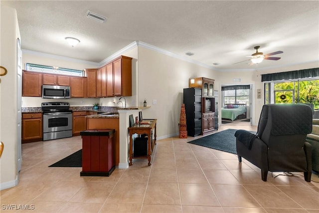 kitchen featuring ceiling fan, light tile patterned floors, stainless steel appliances, and ornamental molding