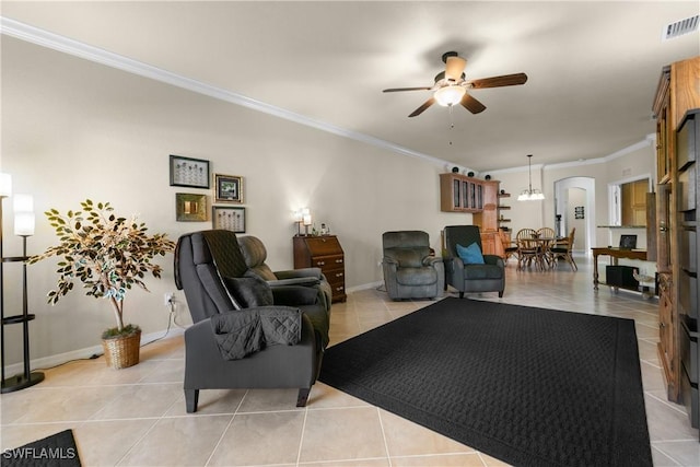 living room featuring light tile patterned flooring, ceiling fan with notable chandelier, and ornamental molding