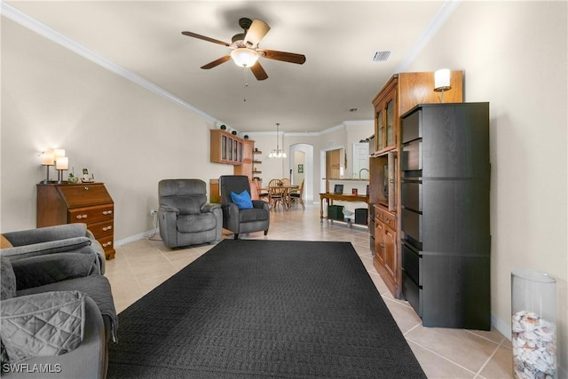 tiled living room with ceiling fan and ornamental molding