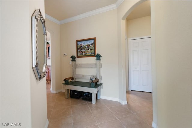 corridor with ornamental molding and light tile patterned flooring