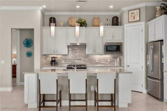 kitchen featuring white cabinetry, stainless steel appliances, hanging light fixtures, and an island with sink