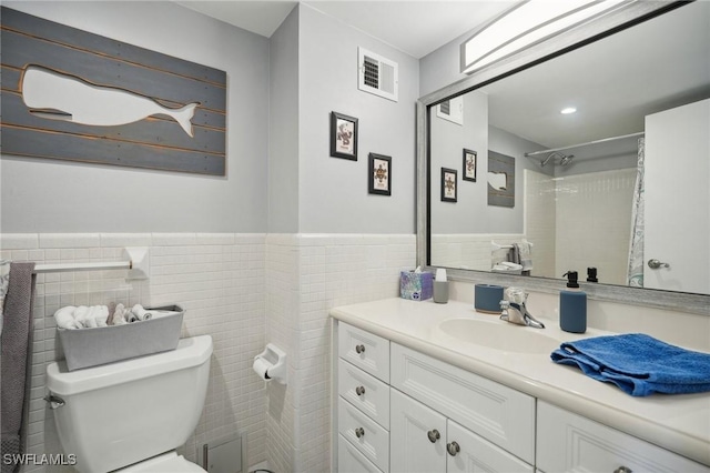 bathroom with a shower with curtain, vanity, tile walls, and toilet