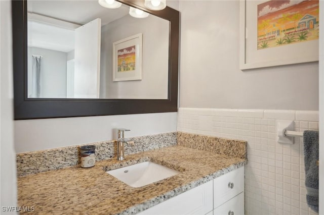 bathroom featuring vanity and tile walls