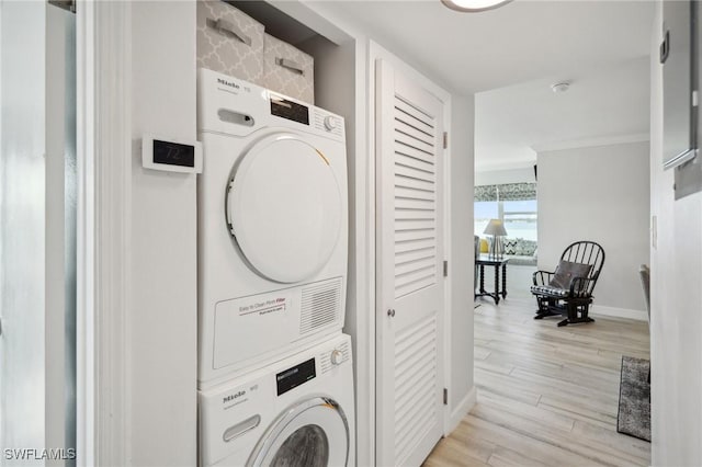 washroom with stacked washer and clothes dryer and light wood-type flooring