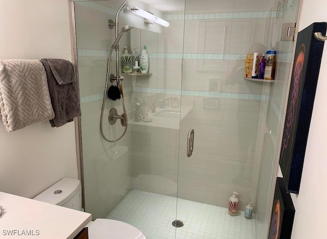 bathroom with a shower with door, vanity, and toilet