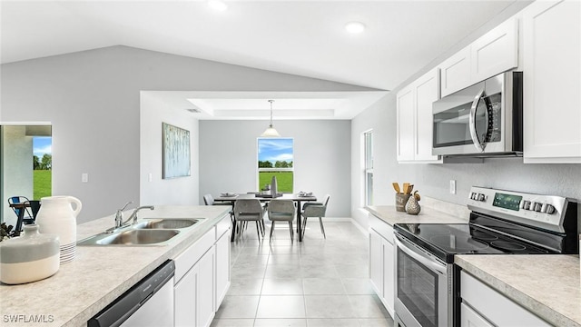 kitchen with appliances with stainless steel finishes, sink, light tile patterned floors, pendant lighting, and white cabinets