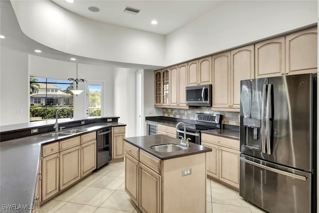 kitchen with appliances with stainless steel finishes, a kitchen island with sink, sink, light tile patterned floors, and a high ceiling