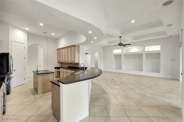 kitchen featuring beamed ceiling, light brown cabinetry, coffered ceiling, and sink