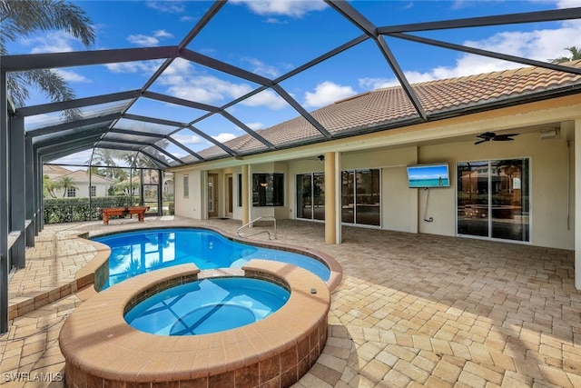 view of swimming pool with glass enclosure, an in ground hot tub, a patio area, and ceiling fan