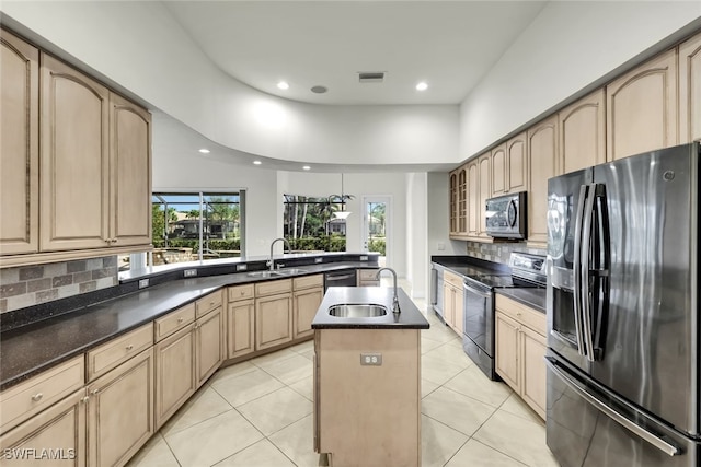 kitchen featuring sink, a kitchen island, light tile patterned floors, and appliances with stainless steel finishes