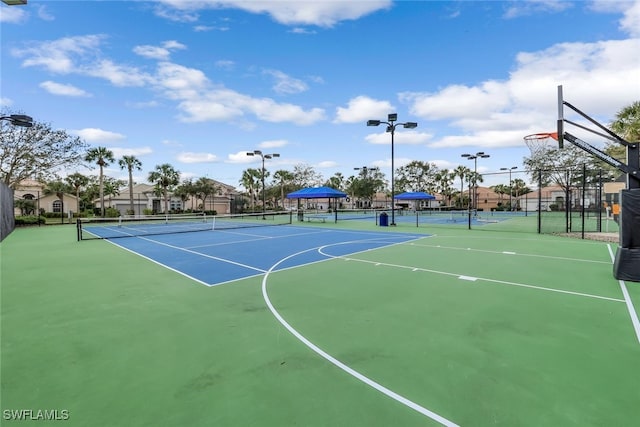 view of basketball court featuring a tennis court, community basketball court, and fence