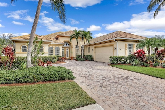 mediterranean / spanish home with a garage and a front lawn